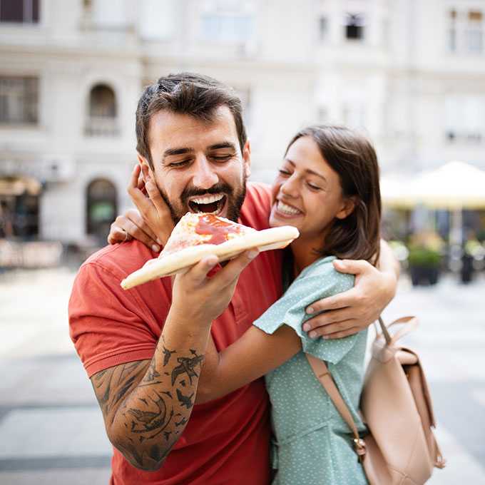 Privatkredit Kassel: Paar im Urlaub isst Pizza